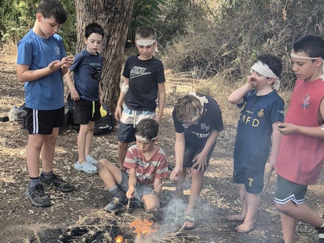 ילדים סביב מדורה ביער